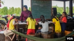 អ្នកនាង សឿន ស្រីនិត អាយុ២៥ឆ្នាំ ជាគ្រូបង្រៀន ថ្នាក់ទី២ កំពុងបង្រៀនថ្នាក់ជាបណ្តុំដល់សិស្សថ្នាក់ទី២ ក្នុងស្រុកសំឡូត ខេត្តបាត់ដំបង កាលពីថ្ងៃទី១៧ ខែមិថុនា ឆ្នាំ២០២០។ (ខាន់ សុគុំមនោ/វីអូអេ)