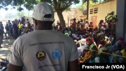 Mfanyakazi wa Shirika la Chakula Duniani, WFP, na watu waliolazimika kukimbia makazi yao wakisubiri maelekezo ya utaratibu wa kupatiwa Chakula huko Cabo Delgado. Picha hii imepigwa Aprili 5, 2021.