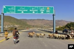 In this Dec. 22, 2017, photo, a Pakistani motorcyclist drives on a newly built Pakistan China Silk Road in Haripur, Pakistan.