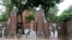 FILE - In this Aug. 13, 2019, file photo, pedestrians walk through the gates of Harvard Yard at Harvard University in Cambridge, Mass. Harvard and the Massachusetts Institute of Technology filed a federal lawsuit Wednesday, July 8, 2020, challenging the T