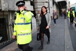 FILE - Labor MP Luciana Berger leaves a meeting organized by the Jewish Labor Movement at the annual Labor Party Conference, accompanied by police protection, in Liverpool, Britain, Sept. 23, 2018.