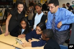 Students use an e-reader at the Bronx Academy of Promise where the Verizon Foundation announced national survey results that surprisingly reveal middle school students use mobile technology to do homework, Wednesday, Nov. 28, 2012.