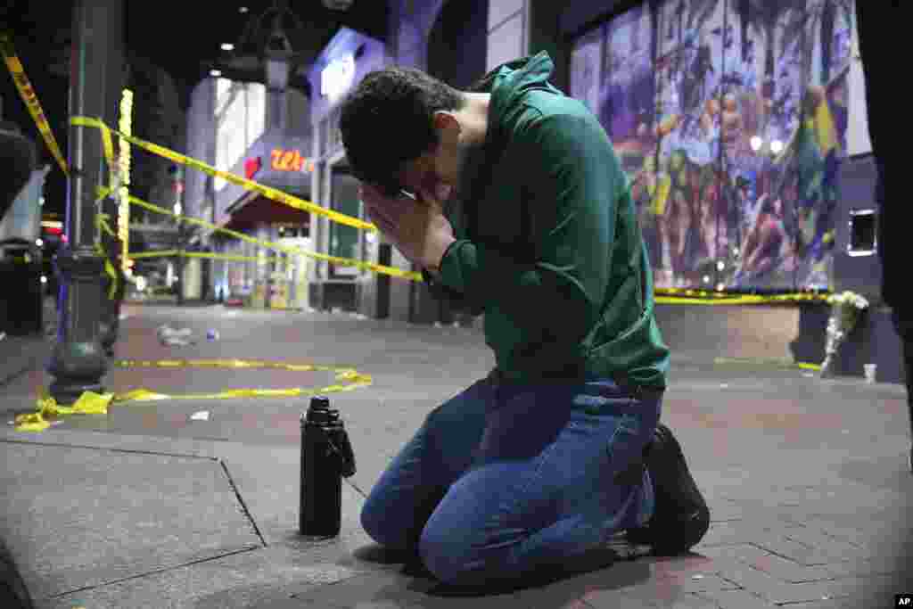 Matthias Hauswirth of New Orleans prays on the street near the scene where a vehicle drove into a crowd on New Orleans' Canal and Bourbon streets, Jan. 1, 2025.