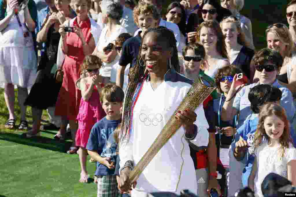 Venus Williams of the U.S. waits with the Olympic Torch on Murray Mound (also known as Henman Hill) at the All England Lawn Tennis Club before the start of the London 2012 Olympic Games in London July 23, 2012. 
