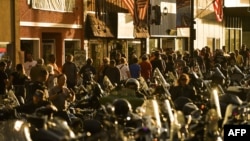 STURGIS, SD - AUGUST 08: People walk along Main Street during the 80th Annual Sturgis Motorcycle Rally in Sturgis, South Dakota on August 8, 2020. While the rally usually attracts around 500,000 people, officials estimate that more than 250,000…