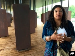 Angel Smith Dixon stands inside a display at the National Memorial for Peace and Justice, April 26, 2018, in Montgomery, Ala.