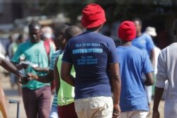 In this April 7, 2020 photo, a man wears a T- shirt with an advertisement regarding contraceptives, in Harare. Lockdowns imposed to curb the coronavirus’ spread have put millions of women in Africa, Asia and elsewhere out of reach of birth control.