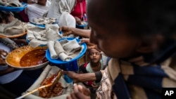 A young boy looks up at a reception center for the internally displaced in Mekele, in the Tigray region of northern Ethiopia, on Sunday, May 9, 2021. (AP Photo/Ben Curtis)