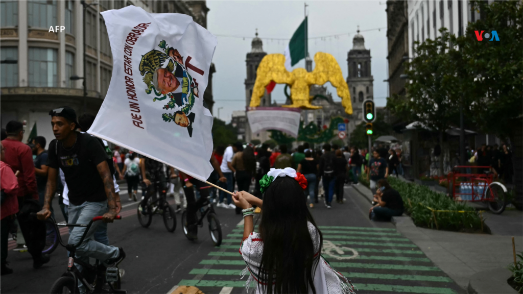 Una niña ondea una bandera que representa al presidente mexicano Andrés Manuel López Obrador, antes de la ceremonia del 'Grito de Independencia', que marca el inicio de las celebraciones del Día de la Independencia cerca de la Plaza El Zócalo en la Ciudad de México.