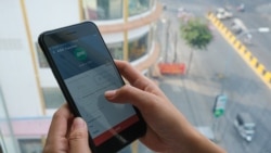 ស្ត្រីម្នាក់ប្រើទូរស័ព្ទស្មាតហ្វូនដើម្បីប្រើសេវាធនាគារ Easy Cash ដែលជាបណ្ដាញ ATM ធំជាងគេបំផុតនៅក្នុងប្រទេសកម្ពុជា នៅរាជធានីភ្នំពេញ កាលពីថ្ងៃទី២ ខែមីនា ឆ្នាំ២០២១។ (ទុំ ម្លិះ/វីអូអេ)