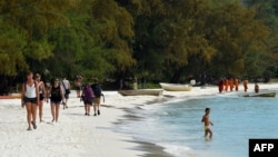 រូបឯកសារ៖ អ្នកទេសចរដើរនៅតាមឆ្នេរសមុទ្រនៅកោះរ៉ុង ខេត្តព្រះសីហនុ កាលពីថ្ងៃទី ៣១ ខែតុលា ឆ្នាំ ២០១៩។