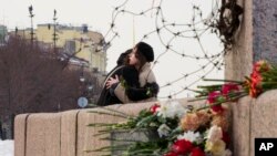 Žene se grle nakon polaganja cvijeća na Memorijal žrtvama političke represije kako bi odali počast Alekseju Navalnom u Sankt Peterburgu, 20. februar 2024.