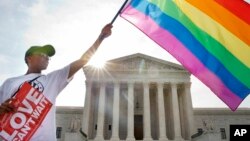 Carlos McKnight of Washington, waves a flag in support of gay marriage outside of the Supreme Court in Washington, D.C., June 26, 2015. 