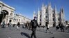 Un hombre con mascarilla pasa ante la catedral gótica del Duomo en Milán, Italia, el domingo 23 de febrero de 2020. (AP Foto/Luca Bruno)