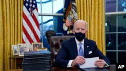 ប្រធានាធិបតីសហរដ្ឋអាមេរិកលោក Joe Biden ក្នុងអំឡុងពេលចុះហត្ថលេខាលើបទបញ្ជានីតិប្រតិបត្តិជាលើកដំបូងរបស់លោក ក្នុងនាមជាប្រធានាធិបតីថ្មីរបស់សហរដ្ឋអាមេរិក ក្នុងការិយាល័យប្រធានាធិបតីនៅសេតវិមាន ថ្ងៃពុធ ទី២០ ខែមករា ឆ្នាំ២០២១។