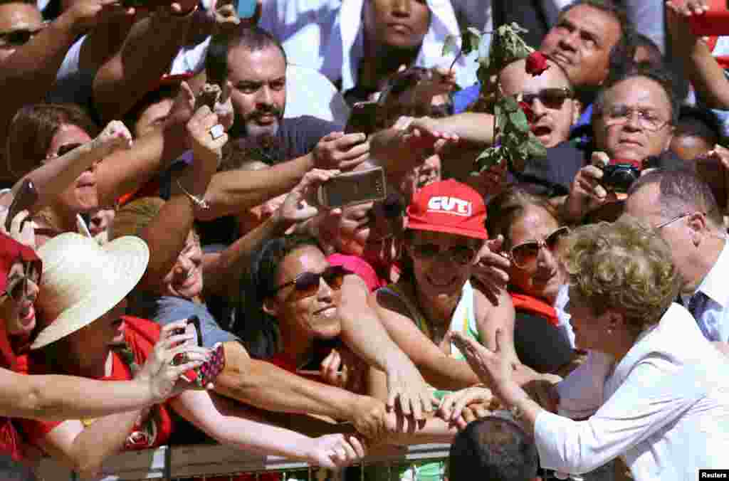 A Presidente suspensa, Dilma Rousseff, cumprimenta os seus apoiantes à saída do Palácio do Planalto em Brasília.