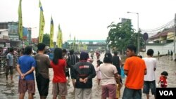 Residents of Kampung Melayu look at the flood waters on a bridge, South Jakarta, Indonesia, January 17, 2013. (K. Lamb/VOA)