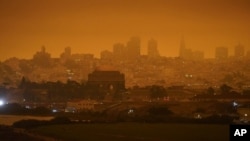 FILE - In this Sept. 9, 2020, file photo, taken at 11:18 a.m., is a dark orange sky above Crissy Field and the city caused by heavy smoke from wildfires in San Francisco. (AP Photo/Eric Risberg, File)