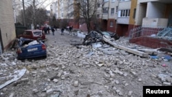 Destroyed cars sit next to an apartment building following what local authorities called a Ukrainian military strike, in Belgorod, Russia, March 24, 2024.