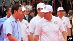 លោក ហ៊ុន ម៉ានី (រូប​កណ្តាល​ខាង​ស្តាំ) កូន​ប្រុស​របស់​លោក​នាយករដ្ឋមន្ត្រី​ ហ៊ុន សែន ដើរ​លើ​កម្រាល​ព្រំ​ក្រហម​ក្នុង​អំឡុង​ពេល​ពិធី​បុណ្យ​ខួប​ទី​៣៤​នៃ​ការ​ដួល​រលំ​នៃ​របប​ខ្មែរ​ក្រហម​កាល​ពី​ឆ្នាំ​១៩៧៩ ដែល​បាន​ប្រព្រឹត្ត​ធ្វើ​នៅ​ស្នាក់ការ​​កណ្តាល​គណបក្ស​ប្រជាជន​កម្ពុជា​កាល​ពី​ថ្ងៃ​ទី​៧ ខែ​មករា ឆ្នាំ​២០១៣។ (AP Photo/Heng Sinith)