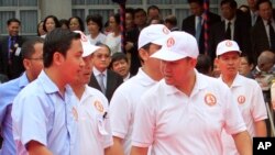 លោក ហ៊ុន ម៉ានី (រូប​កណ្តាល​ខាង​ស្តាំ) កូន​ប្រុស​របស់​លោក​នាយករដ្ឋមន្ត្រី​ ហ៊ុន សែន ដើរ​លើ​កម្រាល​ព្រំ​ក្រហម​ក្នុង​អំឡុង​ពេល​ពិធី​បុណ្យ​ខួប​ទី​៣៤​នៃ​ការ​ដួល​រលំ​នៃ​របប​ខ្មែរ​ក្រហម​កាល​ពី​ឆ្នាំ​១៩៧៩ ដែល​បាន​ប្រព្រឹត្ត​ធ្វើ​នៅ​ស្នាក់ការ​​កណ្តាល​គណបក្ស​ប្រជាជន​កម្ពុជា​កាល​ពី​ថ្ងៃ​ទី​៧ ខែ​មករា ឆ្នាំ​២០១៣។ (AP Photo/Heng Sinith)