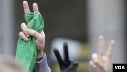 Manifestantes hacen la señal de victoria durante una demostración frente a la embajada iraní en Bruselas.