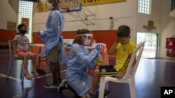 Medicinski radnici testiraju djecu na koronavirus u Izraelu. (Foto: AP/Ariel Schalit)