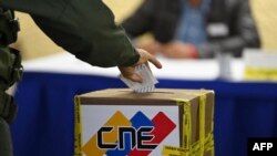 Un miembro de la Guardia Nacional Bolivariana emite su voto en un colegio electoral durante las elecciones regionales y municipales en Fuerte Tiuna en Caracas, el 21 de noviembre de 2021.