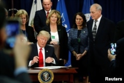 U.S. President Donald Trump signs an executive order at Homeland Security headquarters in Washington, U.S., January 25, 2017