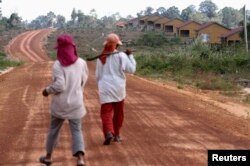 រូប​ឯកសារ៖ ស្ត្រី​ពីរ​នាក់​ដើរលើ​ផ្លូវ​មួយក្នុងឧទ្យានជាតិ​បុទុមសាគរ​ខេត្ត​កោះកុង ដែល​ត្រូវ​បាន​សាងសង់​សម្រាប់​អ្នក​ដែល​ត្រូវ​បានជម្លៀសចេញ​ពី​ដី​ដែល​ត្រូវ​បាន​លក់។ រូបថត ​កាលពីថ្ងៃ​ទី​២០ ខែ​កុម្ភៈ ឆ្នាំ​២០១២។