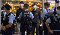 贤学思政召集人王逸战（蓝色口罩者）等4名成员以及3名市民共7人，被警察截查后被拘捕，12月1日凌晨全部获准保释。 (美国之音特约记者汤惠芸摄)