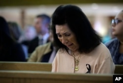 A woman reacts during a special service at Guardian Angel Cathedral after the mass shooting on the Las Vegas Strip, Oct. 2, 2017, in Las Vegas.