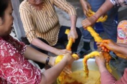 អ្នកស្រី មុំ ឡាយ ធ្វើការនៅនៅអង្គការ វិទ្យាស្ថានវាយនភណ្ឌប្រពៃណីខ្មែរ Institute of Khmer Traditional Textiles កំពុងតែជ្រលក់សូត្រជាមួយនឹងលក្ខធម្មជាតិឲ្យចេញពណ៌លឿងជាមួយនឹងអ្នករួមការងាររបស់អ្នកស្រី នៅក្នុងស្រុកអង្គរធំខេត្តសៀមរាប កាលពី ថ្ងៃទី២១ ខែកក្កដា ឆ្នាំ២០២០។