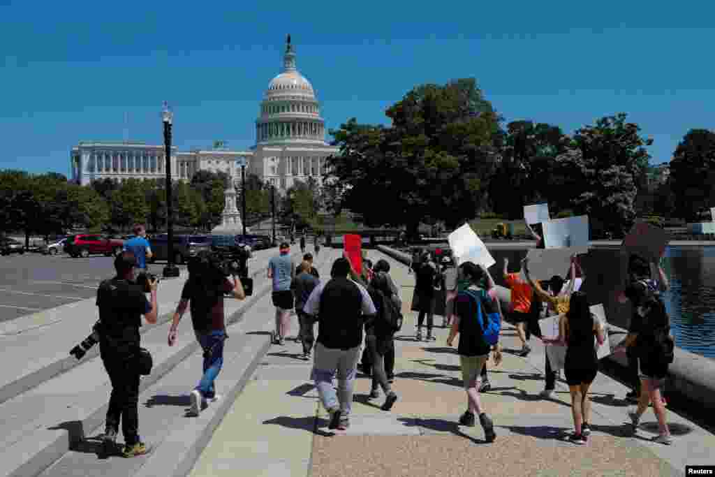 Este sábado, manifestantes sostienen pancartas mientras marchan hacia el Capitolio, en Washington.