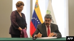 Fotografía difundida por el despacho del presidente venezolano, Nicolás Maduro, mientras firma el libro de visitantes distinguidos del Nuevo Banco de Desarrollo de los BRICS, en presencia de Dilma Rousseff, en Shanghái, China, el 10 de septiembre de 2023.