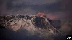 FILE - In this Oct. 27, 2011, photo, the last light of the day sets on Mount Everest as it rises behind Mount Nuptse as seen from Tengboche, in the Himalaya's Khumbu region, Nepal.