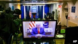 រូប​ភាព​លើ​កញ្ចក់​កុំព្យូទ័រ​យួរដៃ​មួយ​គ្រឿង​បង្ហាញ​ពី​​លោកប្រធានាធិបតី Donald Trump ថ្លែង​ក្នុង​វីដេអូ​មួយ​ ដែល​ត្រូវ​បាន​បង្ហោះ​លើ​គណនី ​​Twitter របស់​សេតវិមាន នៅ​សេតវិមាន ថ្ងៃទី១៣ ខែមករា ឆ្នាំ២០២១។ 