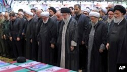 En esta foto de la oficina del líder supremo de Irán, el ayatolá Alí Jamenei lidera una oración sobre los ataúdes envueltos en banderas iraníes del presidente del país, Ebrahim Raisi, y sus compañeros de viaje, durante un funeral en Teherán, el miércoles 22 de mayo de 2024.