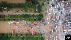 中国北部河北省涿州市洪水期间，救援人员部署救生筏疏散居民。（美联社）