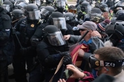 FILE - Capitol Police in riot gear push back demonstrators at the U.S. Capitol, Jan. 6, 2021, in Washington.