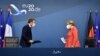 German Chancellor Angela Merkel, right, and French President Emmanuel Macron prepare to address a media conference at the end of an EU summit in Brussels, Tuesday, July 21, 2020. Weary European Union leaders finally clinched an unprecedented budget 