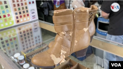 En el mostrador de una talabartería en Caracas, se ven unas botas de vestir que fueron llevadas para su reparación. Enero, 2021. Foto: Captura de video.