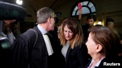 N. Haddadi (C), dont le fils radicalisé a combattu en Syrie où il serait mort en tant que jihadiste, et son avocat H. Denis au tribunal, après le verdict dans le procès où elle est accusée d'avoir aidé et financé le terrorisme, à Paris, France, le 28 sept 2017. REUTERS/P. Wojazer
