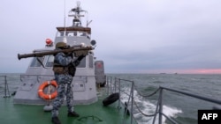 一名烏克蘭軍人肩扛便攜式防空武器“毒刺”在烏克蘭海事防衛隊在西北部黑海的一艘巡邏船上掃描空中目標。 （2023年12月18日）