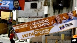 Un correligionario de Henrique Capriles coloca una manta de su candidato, mientras atrás aparece otra de su contincante, el presidente Hugo Chávez.