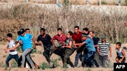 Palestinian protesters carry away a man injured during clashes following a demonstration along the border with Israel east of Bureij in the central Gaza Strip, Sept. 6, 2019.