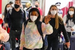 Simone Biles, center, and the U.S. Women's Gymnastics team arrive for the Tokyo 2020 Summer Olympic Games at Narita International Airport Thursday, July 15, 2021, in Narita, east of Tokyo. (AP Photo/Kiichiro Sato)