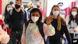 Simone Biles, center, and the U.S. Women's Gymnastics team arrive for the Tokyo 2020 Summer Olympic Games at Narita International Airport Thursday, July 15, 2021, in Narita, east of Tokyo. (AP Photo/Kiichiro Sato)