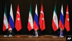 FILE - Turkey's President Recep Tayyip Erdogan, right, Russia's President Vladimir Putin, center, and Iran's President Hassan Rouhani are seen at a news conference following their talks on Syria, in Russia's Black Sea resort of Sochi, Russia, Nov. 22, 2017.