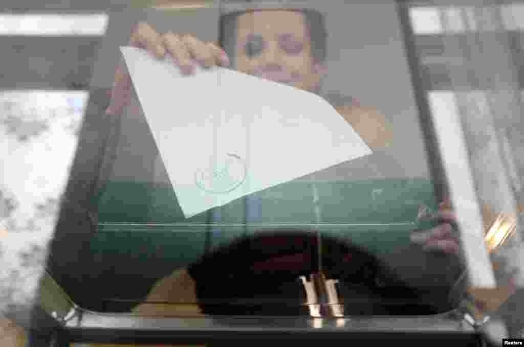 A woman casts her ballot during the referendum on the status of Ukraine's Crimea region at a polling station in Bakhchisaray, Crimea, Ukraine, March 16, 2014. 